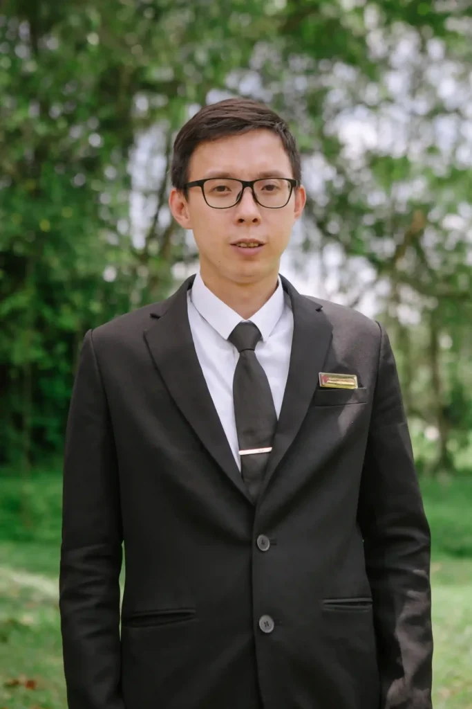 Man in a black suit posing for Amazing Grace